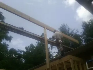 Carpenter setting a ridge beam over a new addition frame — Ice Dam Removal by Roofing Brothers in Richland Center