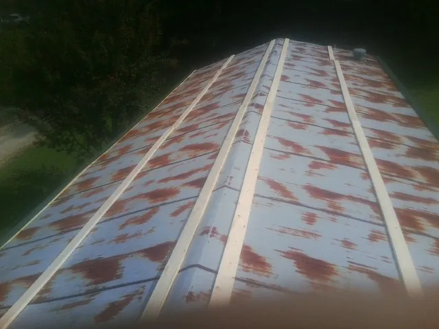 Rusted metal roof panels with new wood purlins before replacement — Storm Damage Roof Repair in Richland Center by Roofing Brothers