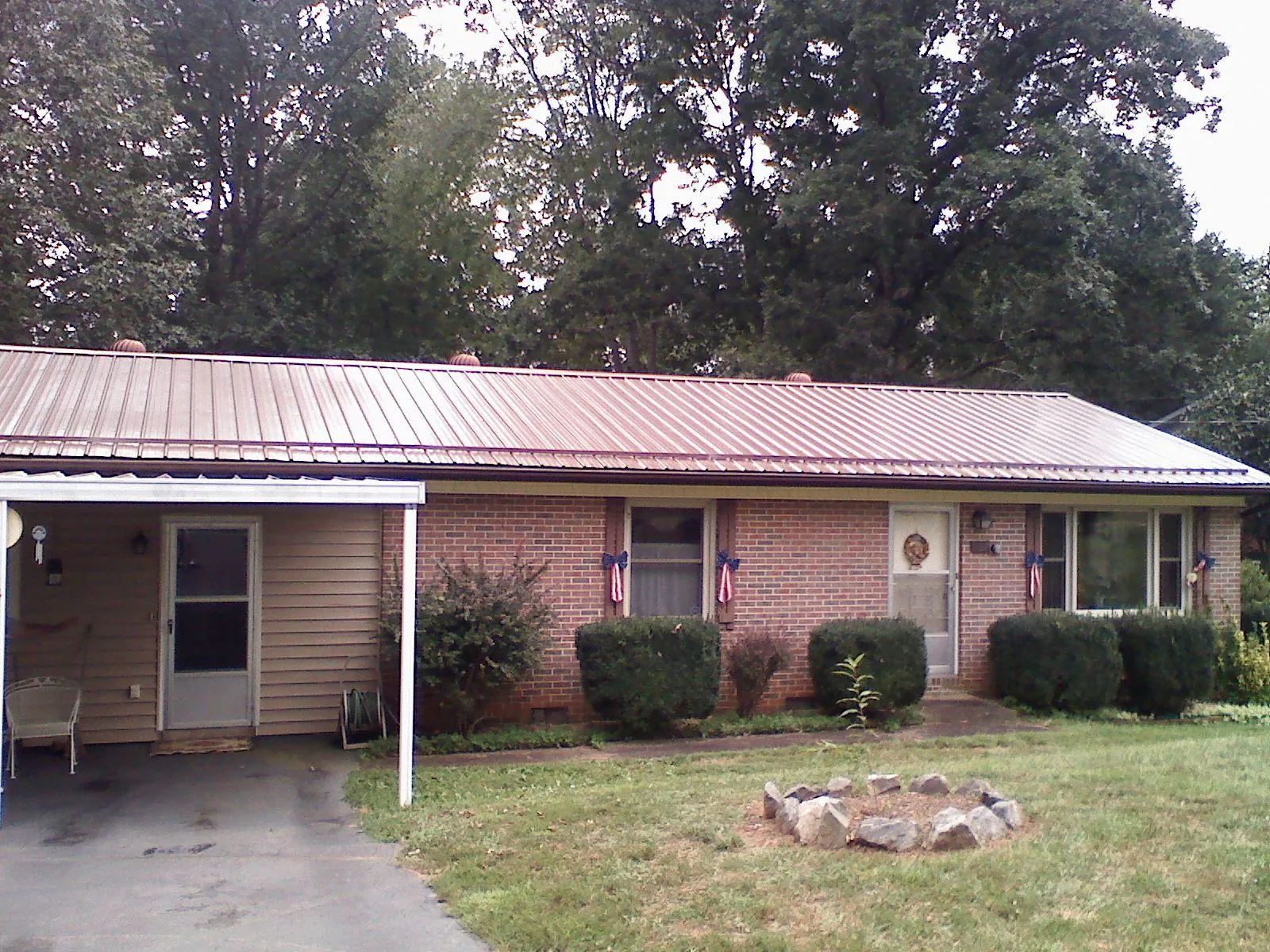 Bronze metal roof and carport on a brick ranch home — Roof Repair work by our crew in Richland Center