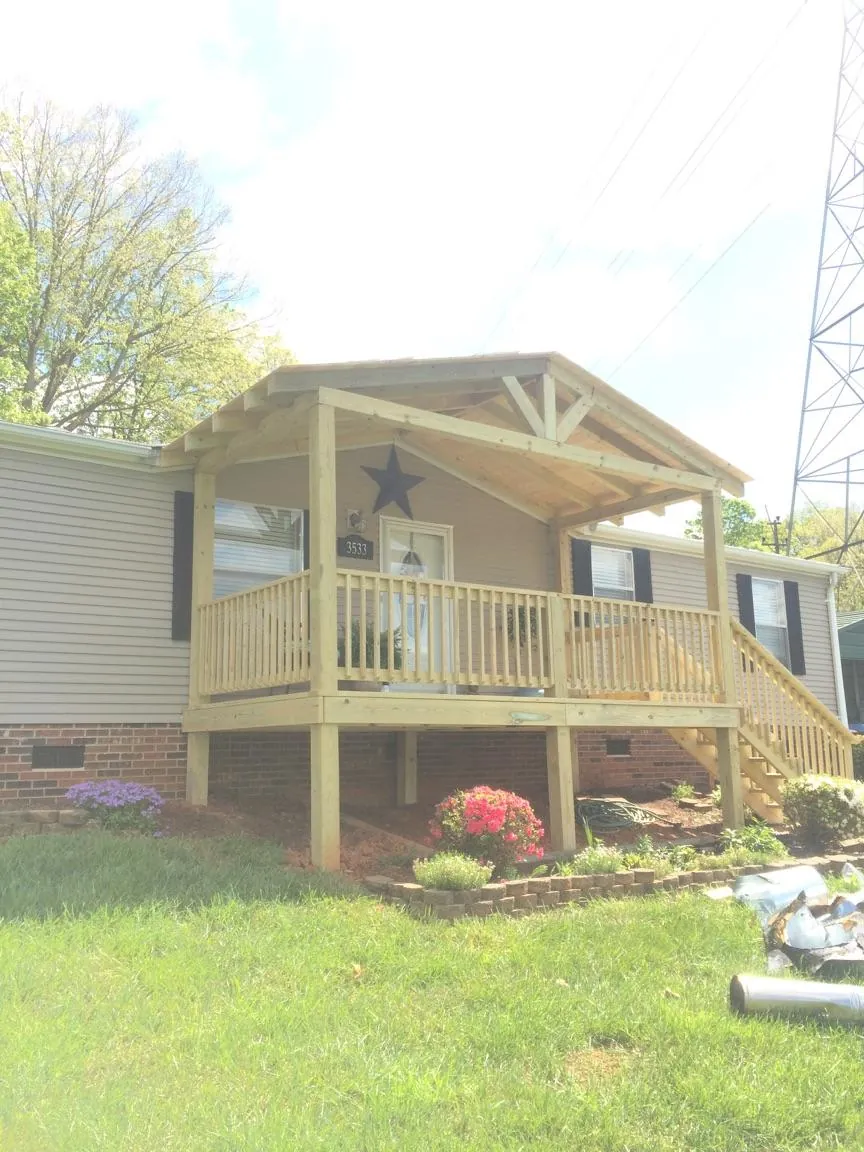 New gabled porch roof and deck railing added to a ranch home in Richland Center